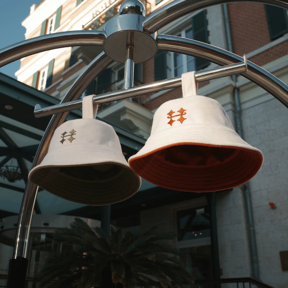 Two Halo wool felt sauna hats hanging by its loop on metal pole outside a hotel