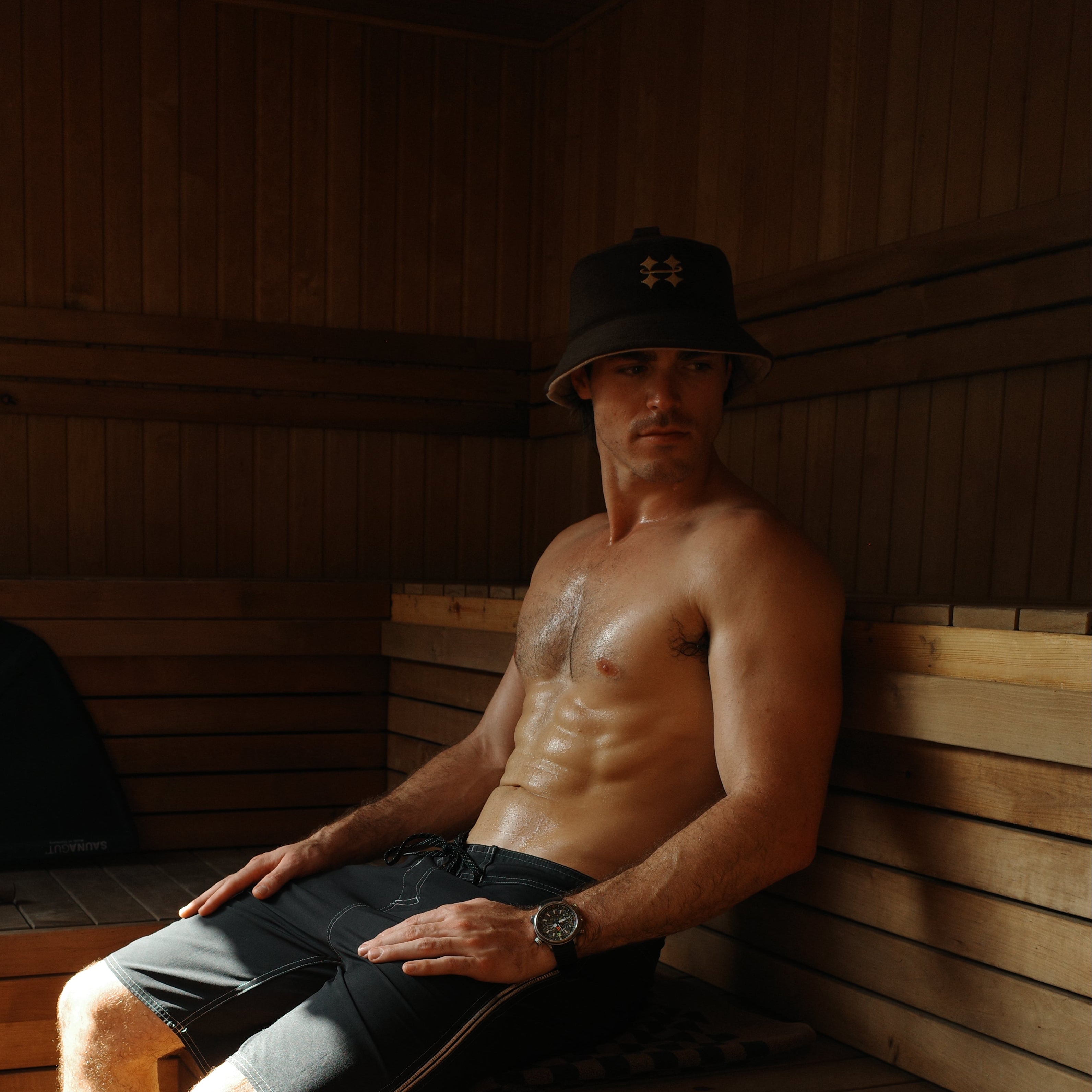 Man sitting in a wooden sauna with sunlight streaming in