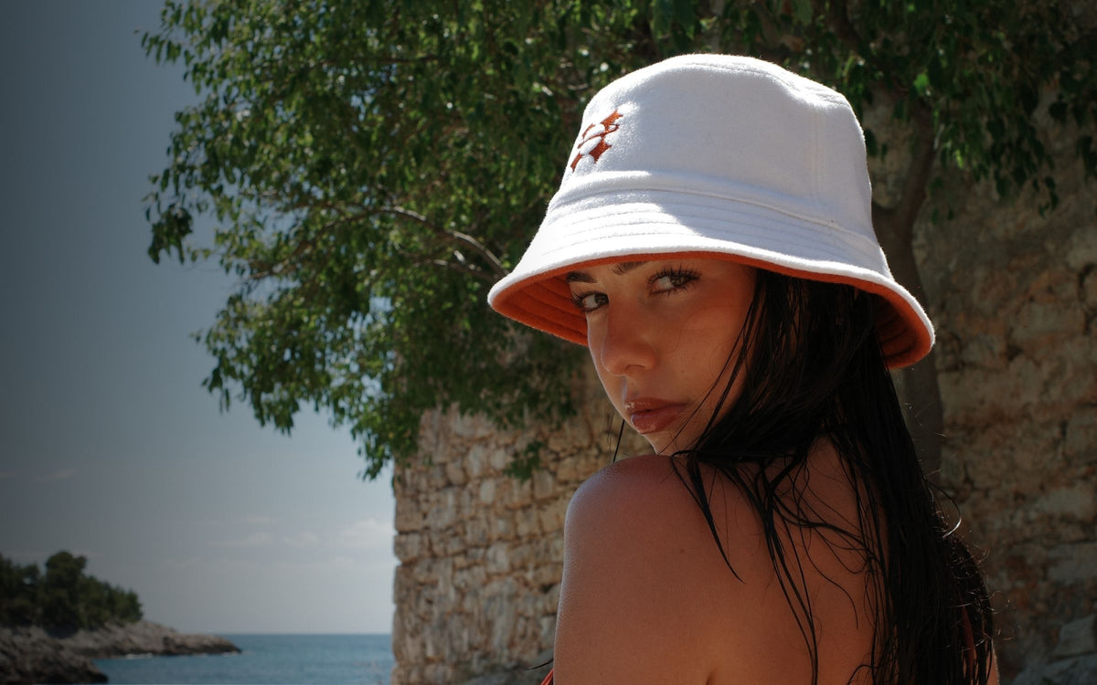 Woman wearing a Halo sauna hat next to a tree